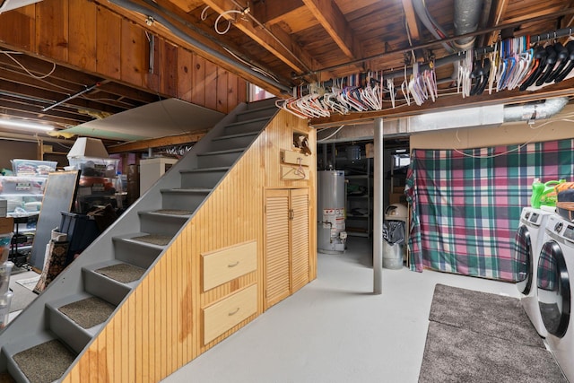 unfinished below grade area with water heater, stairway, and separate washer and dryer