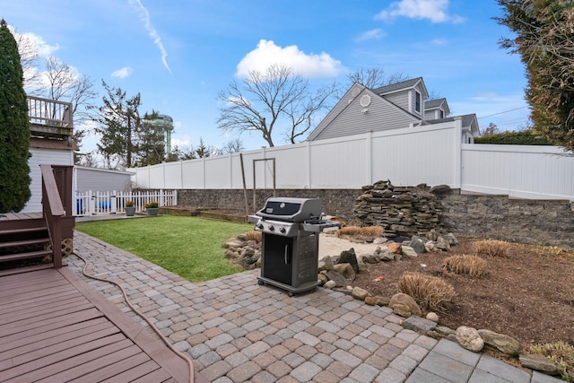 view of patio with a deck, area for grilling, and a fenced backyard