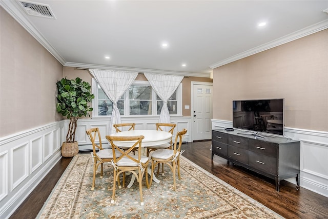 dining area with a wainscoted wall, dark wood-style flooring, a baseboard radiator, and visible vents