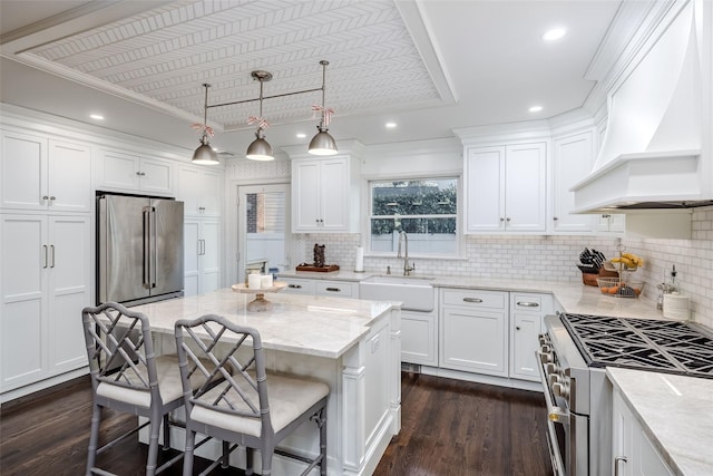 kitchen featuring white cabinetry, a sink, custom exhaust hood, and high quality appliances