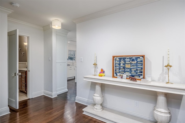 hallway with crown molding, baseboards, and wood finished floors