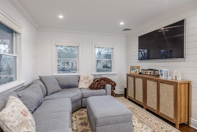 living area featuring crown molding, visible vents, a wealth of natural light, and wood finished floors