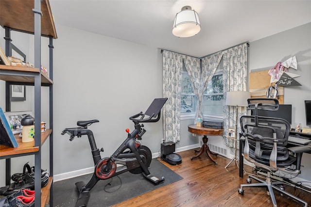 workout room featuring wood finished floors and baseboards