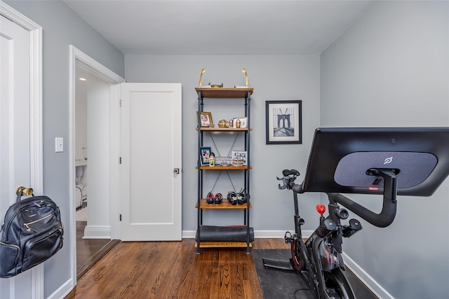 exercise area featuring baseboards and wood finished floors