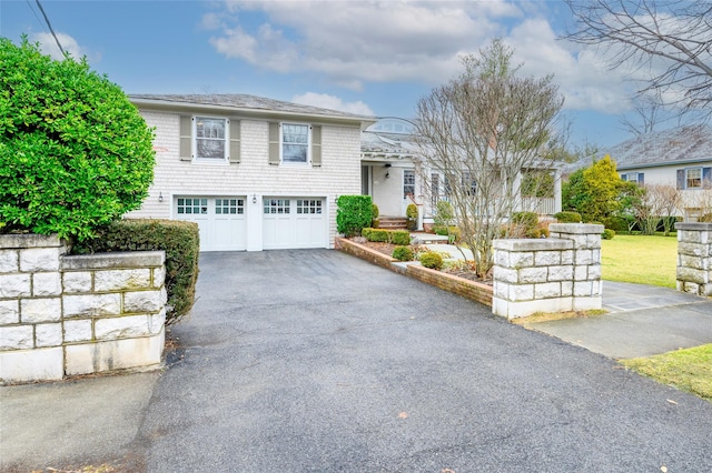 view of front facade featuring a garage and aphalt driveway