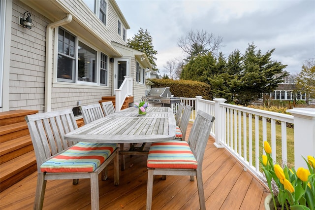 wooden deck with a grill and outdoor dining space