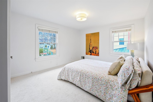 bedroom with multiple windows, carpet, and baseboards