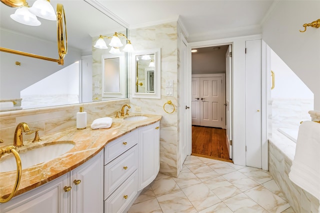 full bathroom with crown molding, a sink, tile walls, and double vanity