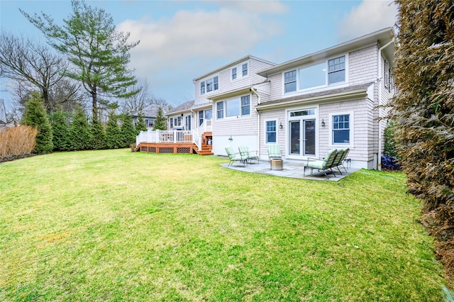 rear view of property featuring a yard, a patio area, and a wooden deck