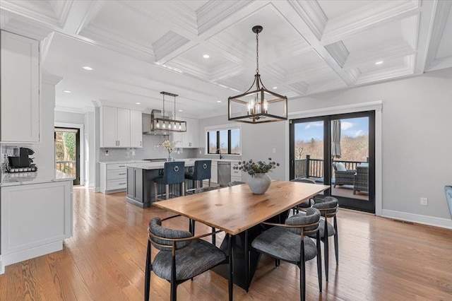 dining space with ornamental molding, light wood-type flooring, and beam ceiling