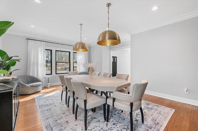 dining space with light wood-type flooring, crown molding, baseboards, and recessed lighting