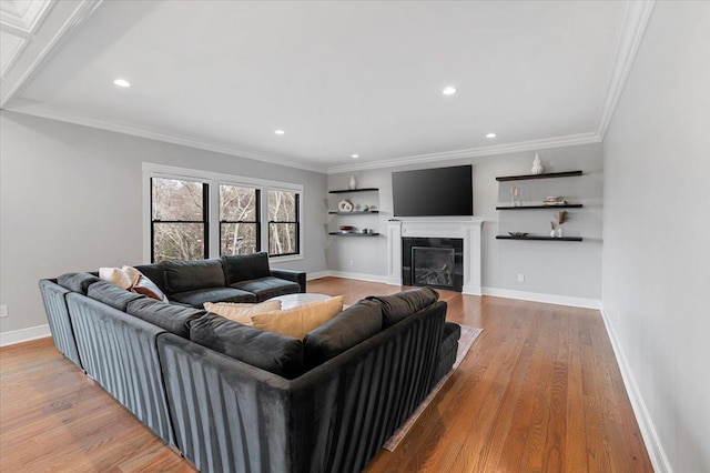 living room featuring ornamental molding, a fireplace, wood finished floors, and baseboards