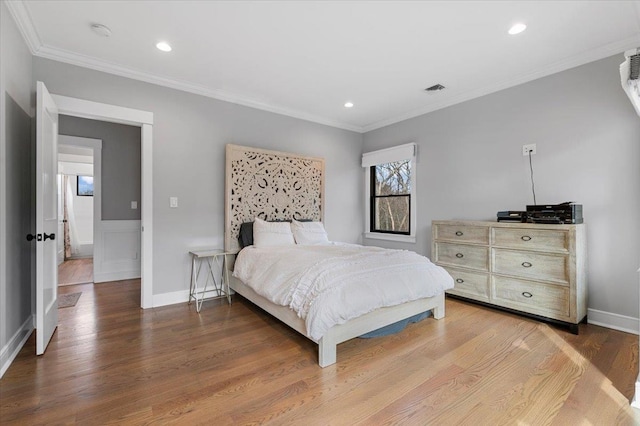 bedroom with visible vents, ornamental molding, wood finished floors, and recessed lighting