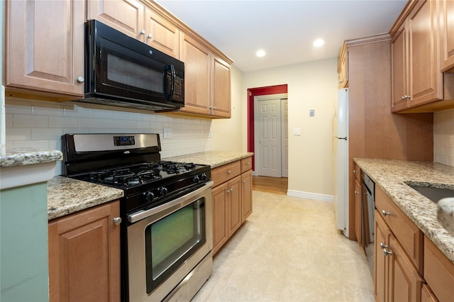 kitchen with light stone counters, stainless steel appliances, recessed lighting, backsplash, and baseboards