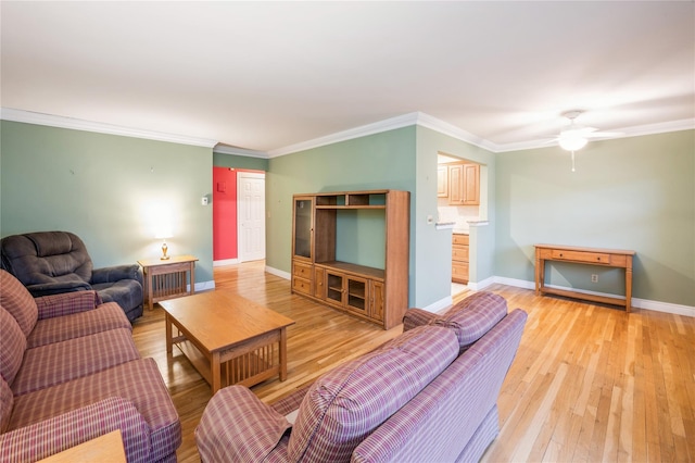 living area with ornamental molding, light wood finished floors, and baseboards