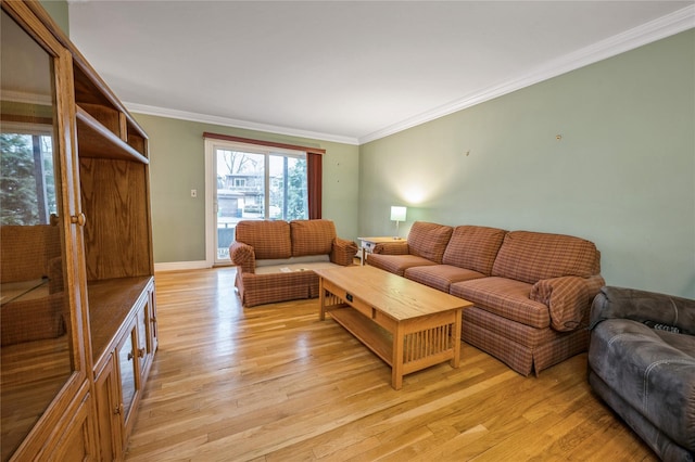 living room featuring baseboards, crown molding, and light wood finished floors