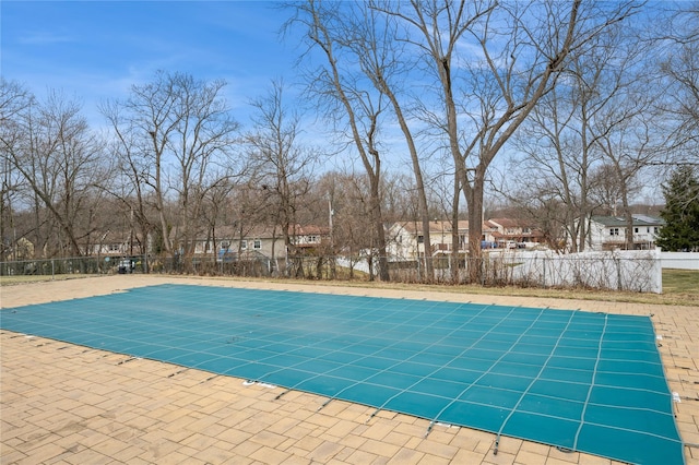 view of swimming pool featuring a residential view, fence, and a patio