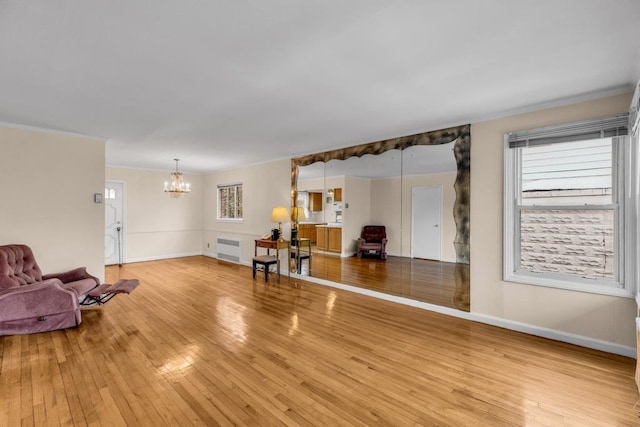 interior space with ornamental molding, light wood-type flooring, baseboards, and an inviting chandelier