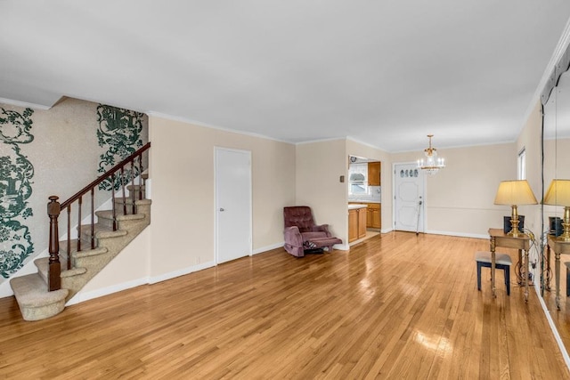 interior space featuring a notable chandelier, light wood finished floors, stairway, ornamental molding, and baseboards