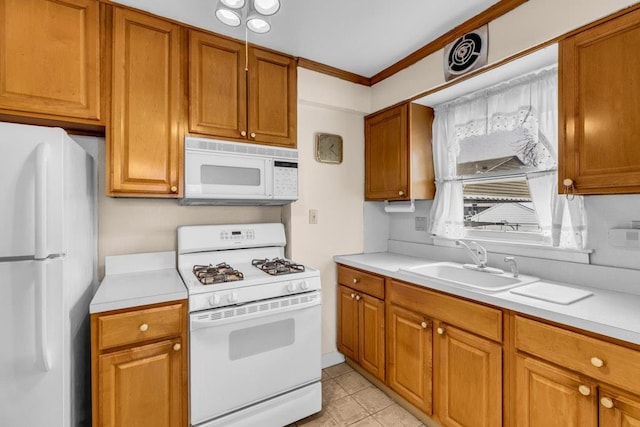 kitchen featuring white appliances, light countertops, and a sink