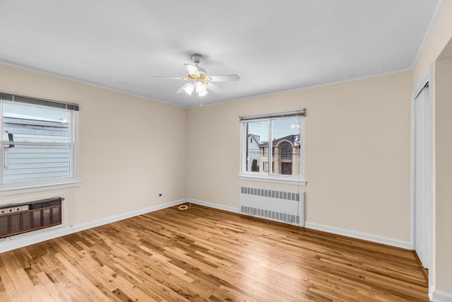 unfurnished bedroom featuring radiator, baseboards, wood finished floors, and ornamental molding