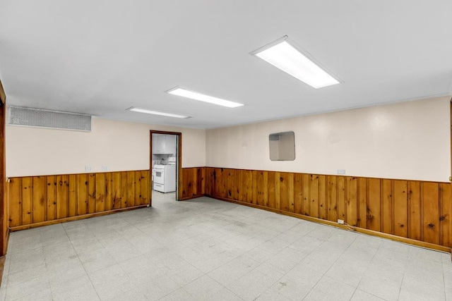 empty room with a wainscoted wall, wood walls, and tile patterned floors