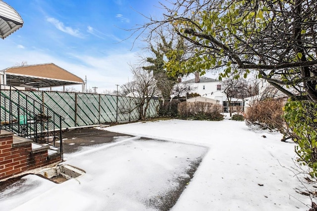 snowy yard featuring fence