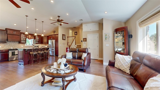 living room featuring lofted ceiling, plenty of natural light, and a ceiling fan