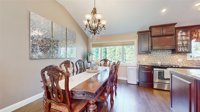 dining area featuring baseboards, vaulted ceiling, dark wood-type flooring, and a chandelier