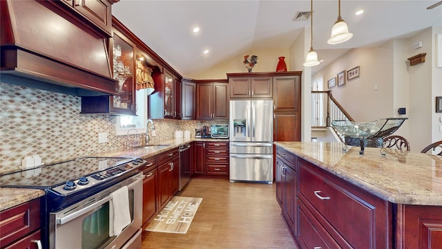 kitchen with decorative backsplash, light stone counters, stainless steel appliances, light wood-type flooring, and a sink