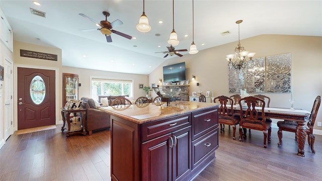 kitchen featuring reddish brown cabinets, dark wood-style floors, visible vents, and vaulted ceiling