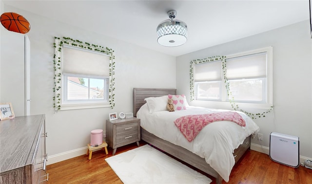 bedroom with baseboards and wood finished floors