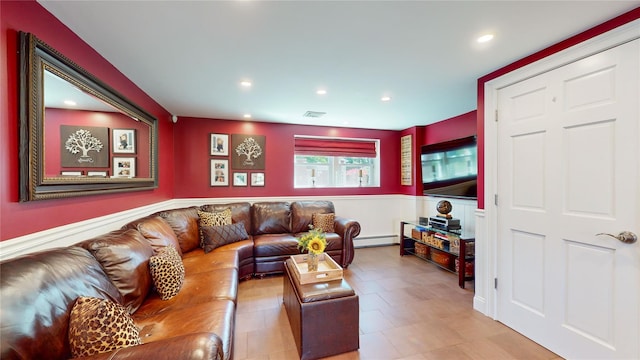 living room featuring baseboard heating, wainscoting, visible vents, and recessed lighting