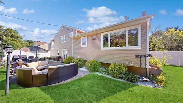 rear view of property with a patio area, outdoor lounge area, a yard, and a fenced backyard