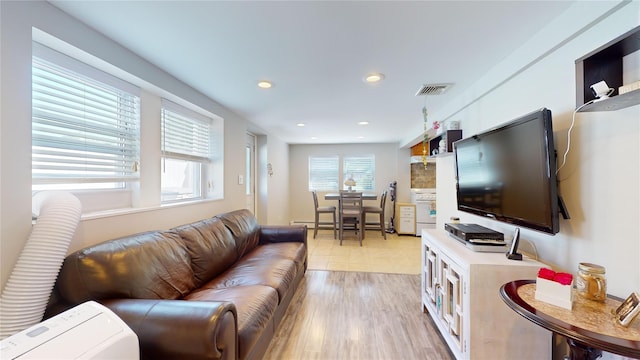 living room with recessed lighting, visible vents, and light wood finished floors