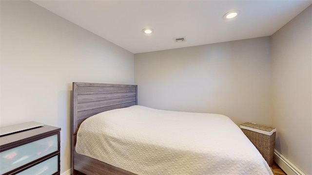 bedroom with a baseboard radiator, recessed lighting, wood finished floors, visible vents, and baseboards