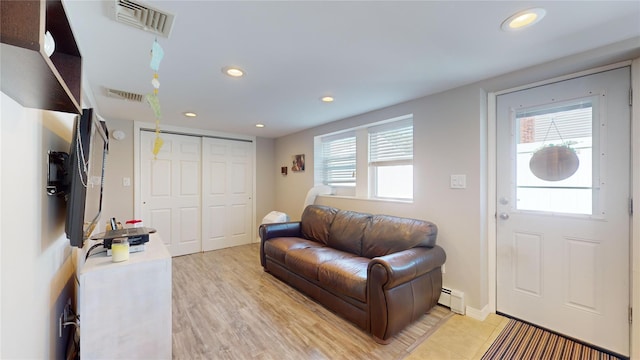 living area with a healthy amount of sunlight, visible vents, baseboard heating, and recessed lighting