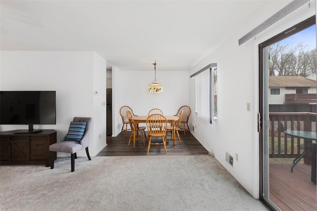 carpeted dining space with visible vents