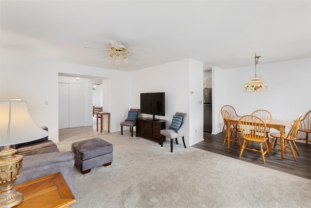 carpeted living room with a ceiling fan