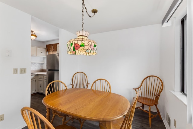 dining room with baseboards and dark wood-style flooring