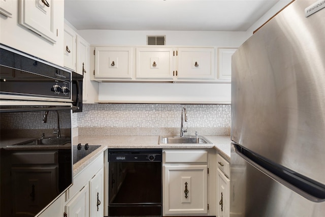 kitchen with black appliances, a sink, and white cabinetry