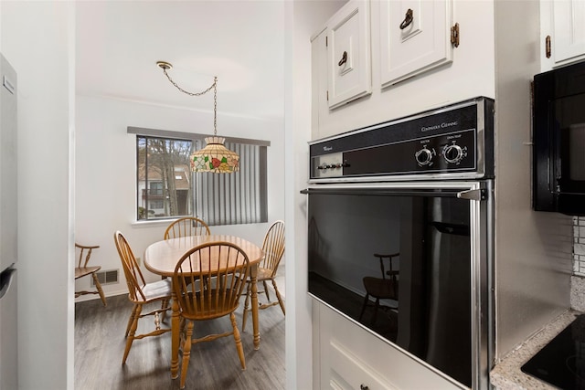 dining room featuring baseboards, visible vents, and wood finished floors