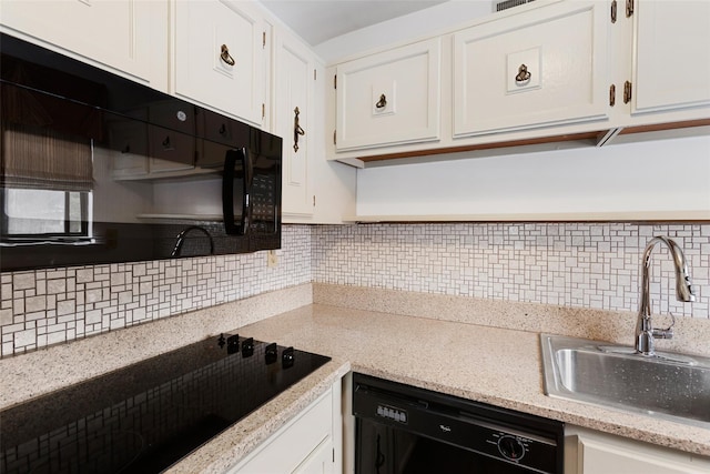 kitchen with black appliances, backsplash, white cabinets, and a sink