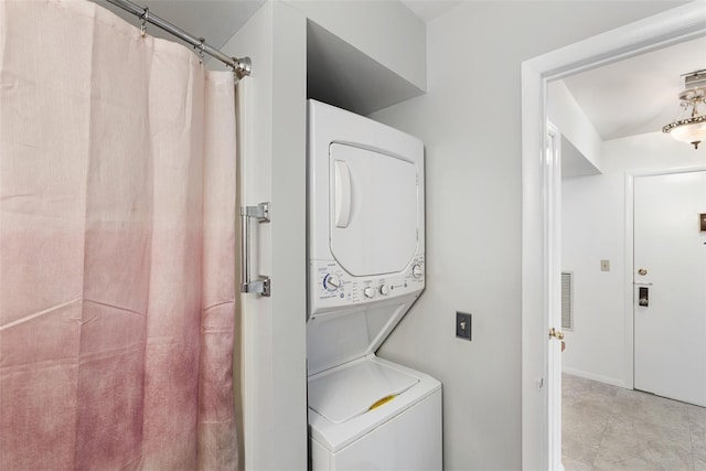 laundry area with laundry area, visible vents, and stacked washer and clothes dryer