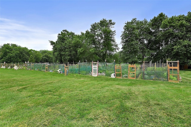 view of play area with a vegetable garden, a yard, and fence