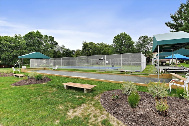 surrounding community with a yard, a tennis court, and fence