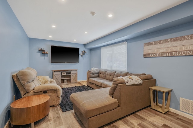 living room featuring baseboards, visible vents, wood finished floors, and recessed lighting