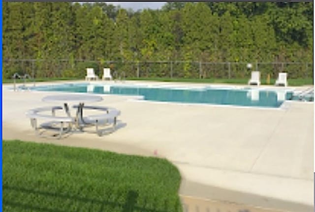 community pool featuring fence and a patio