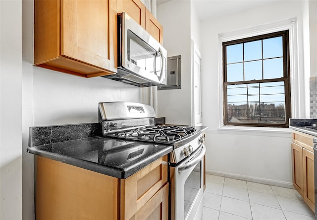 kitchen with light tile patterned floors, baseboards, and appliances with stainless steel finishes