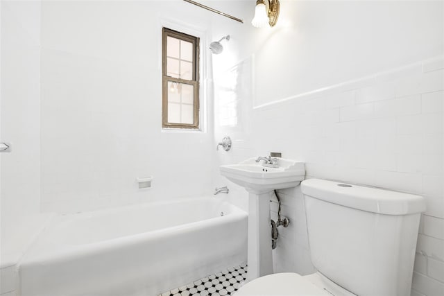 full bathroom with tub / shower combination, toilet, and tile walls